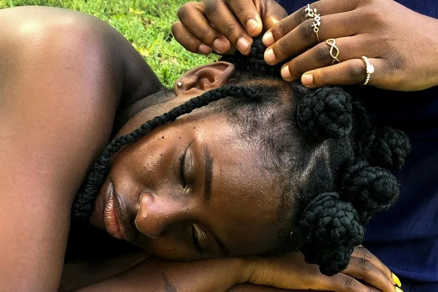 Woman getting her hair braided with synthetic hair